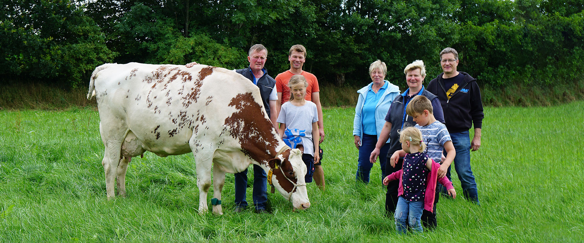 Familie mit Kuh auf der Wiese